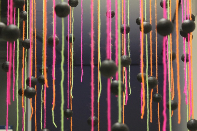 Eyes in the Sky — Detail — black spheres and neon pink and green yarn